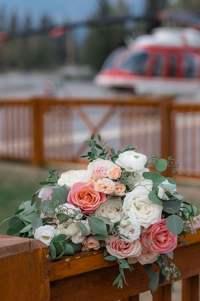 pink and white bridal bouquet with helicopter in background