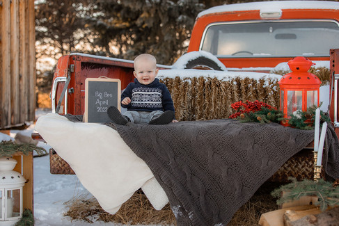 Pregnancy announcement - son sitting with chalkboard sign announcing big brother