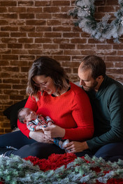 couple cudding with baby for Christmas photos