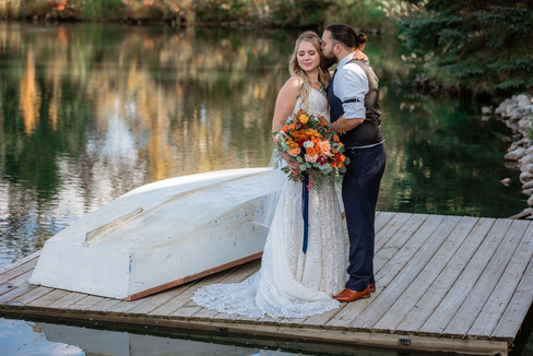 bride and groom take photos on canoe at Pine and Pond