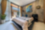 Modern bedroom at Villa Zayden with bed, blue art, and patio access