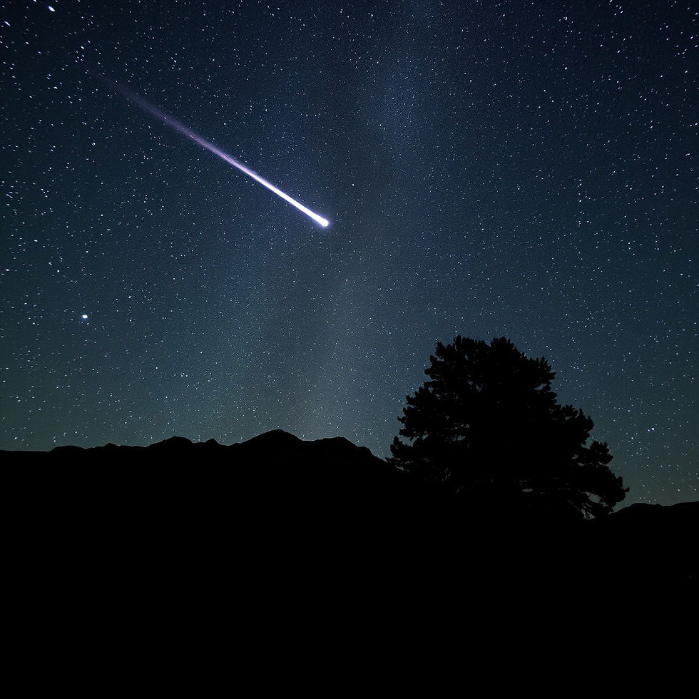 Image of a star filled night sky with a comet flying by.  Background include mountain and 