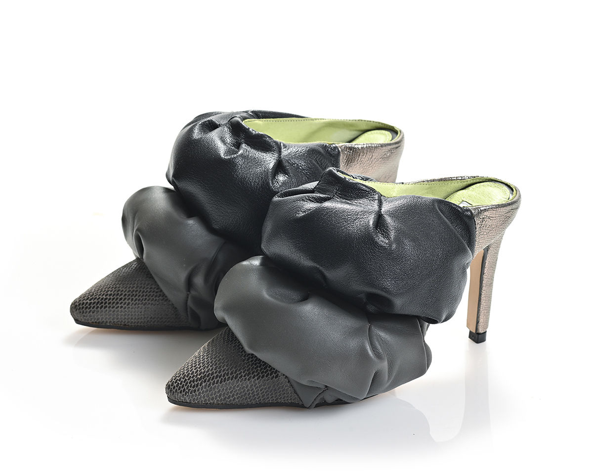 A playful mule with a puffy, exaggerated silhouette and color-blocked greys and blacks leather.
