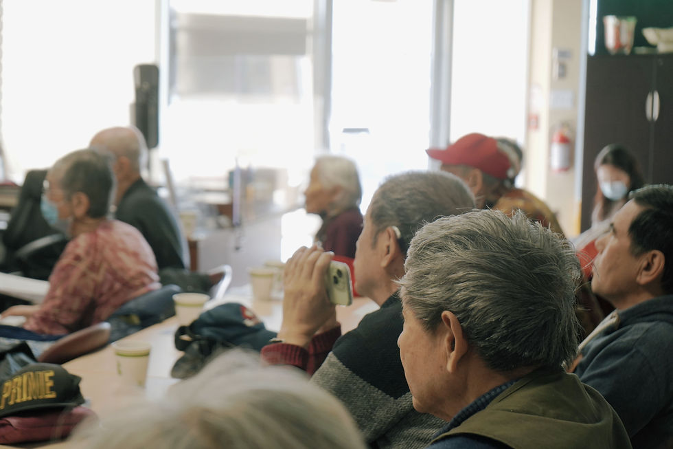 Seniors at Yee Hong listen attentively during WOXY’s health session on blood pressure and body composition, taking notes and recording key points to learn more about their health.
