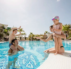 Family with a baby in a resort swimming pool in Da Nang Vietnam enjoying a safe and relaxing tropical holiday at a beachfront hotel with calm water
