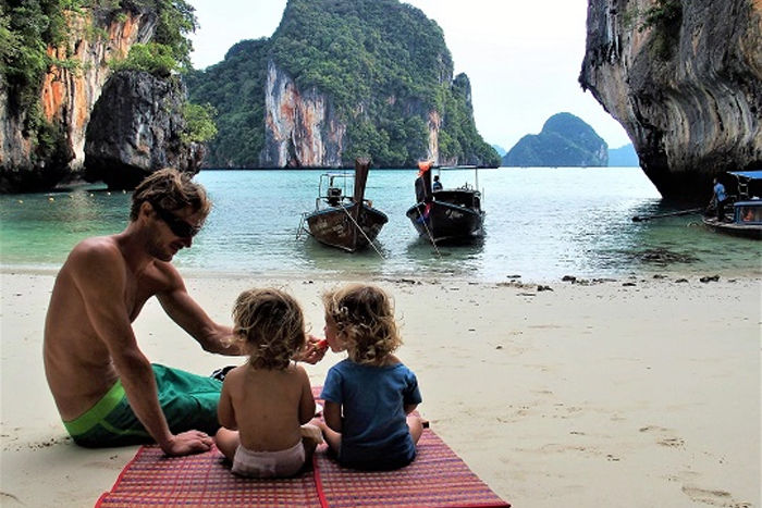 Family traveling in Southeast Asia with baby and toddler on tropical beach