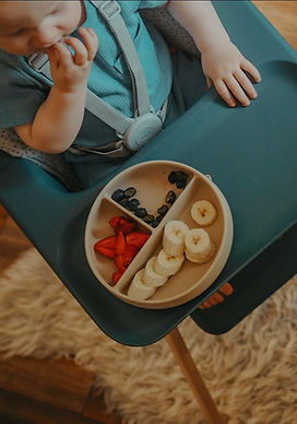 Parent feeding baby in high chair during family travel stay in Da Nang accommodation