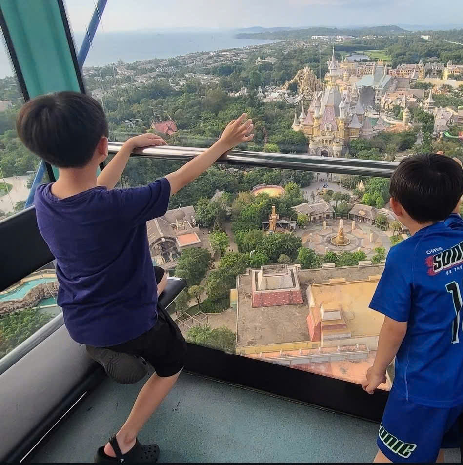 Family riding VinWonders cable car over sea in Phu Quoc with baby and toddler enjoying panoramic island views