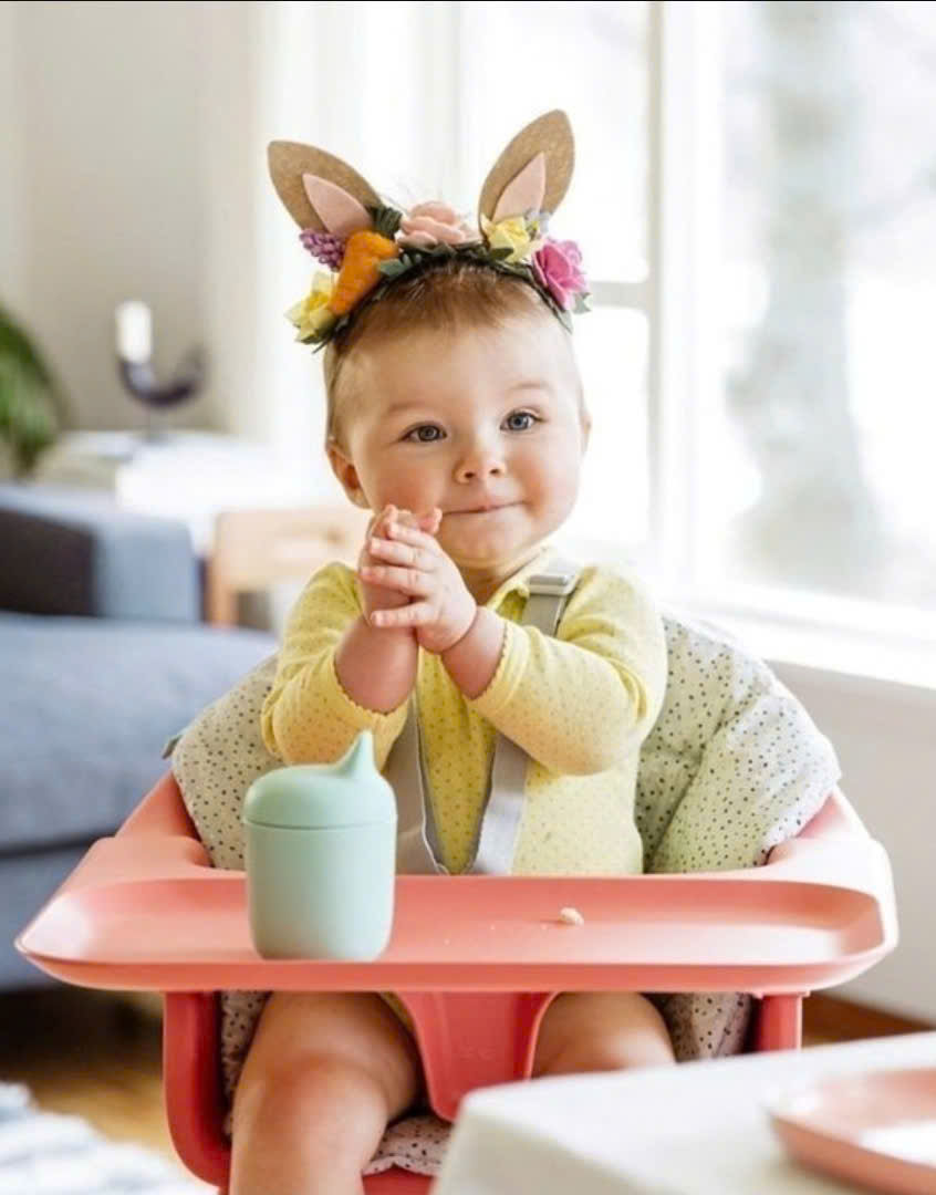 Baby sitting in a high chair during mealtime in a Vietnam hotel room