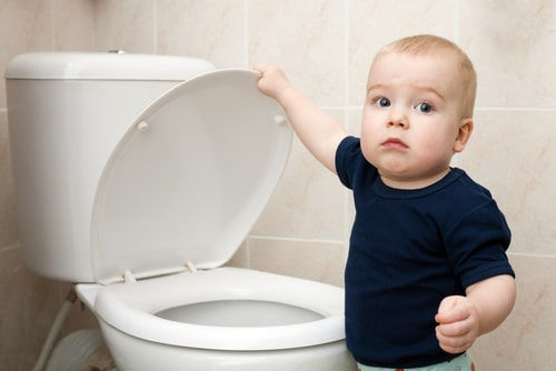 Toddler practicing potty training in a clean hotel room bathroom in Vietnam
