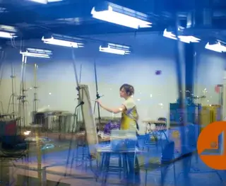 Artist painting on a canvas in a blue-lit studio, photograph by Casey Templeton.
