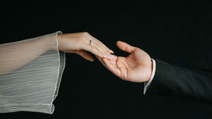 Elegantes Brautpaar reicht sich die Hand bei eleganter schwarz-weißer Hochzeit