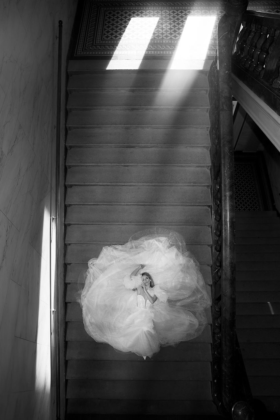Elegante Braut in glamourösem Brautkleid auf einer Treppe