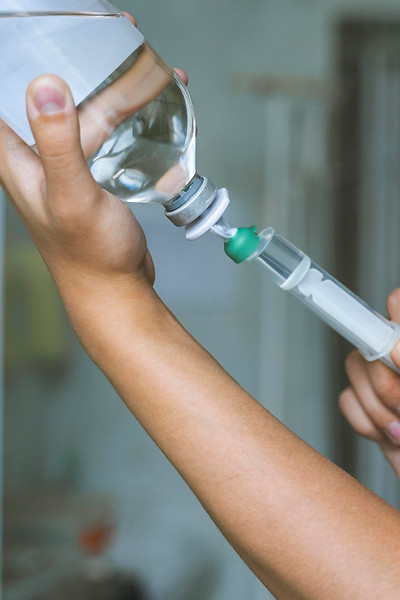 side-view-doctor-filling-up-syringe-with-medicine