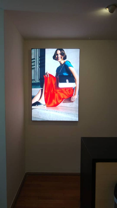 Caja de luz iluminada con mujer con falda roja y cartera furla