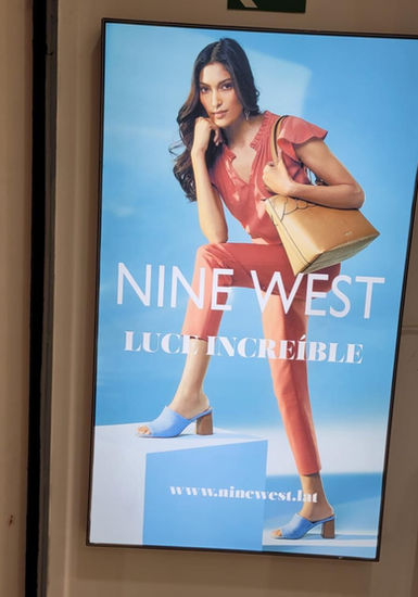 Caja de luz de Nine West con imagen de joven con cartera