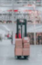 Employee moving boxes with a forklift in a warehouse.