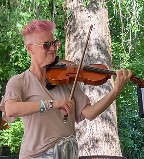 Circe Dopp, violinist with Chamber Orchestra Ogden, professional photograph. Summer afternoon, standing the shade of a tall green tree.