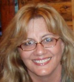 Mary McMillen, treasurer for the Chamber Orchestra Ogden, smiles happily for a candid photograph.