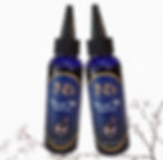 Two bottles of JNJS Nourish Mi Growth Oil with a cherry blossom plant on the bottom