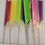 Thumbnail: 8 Rattail Combs: bright green, pastel green, yellow, pink, purple, blue, red, and black all laying down