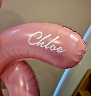 Close-up of a personalised pink number 16 foil balloon with the name Chloe for a birthday balloon display by The Cedars Events.