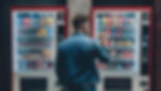 hipster-style-man-viewed-from-back-buying-snacks-drink-from-vending-automatic-machine-typi