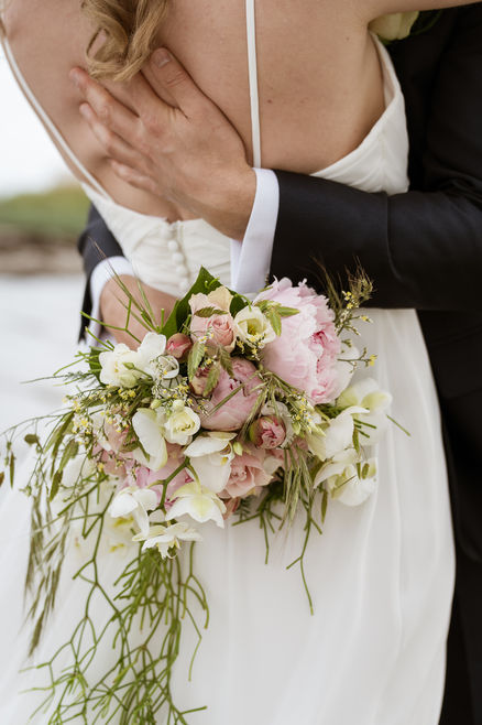 Brudepar omfavner hinanden med blomster, Bryllupsportrætter, bryllupsdag, Dan Mortensen Foto