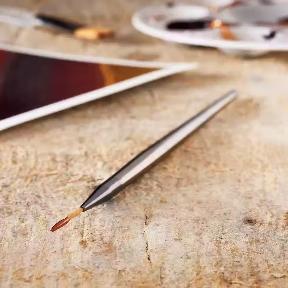 Close-up view of a detail liner brush on a wooden surface