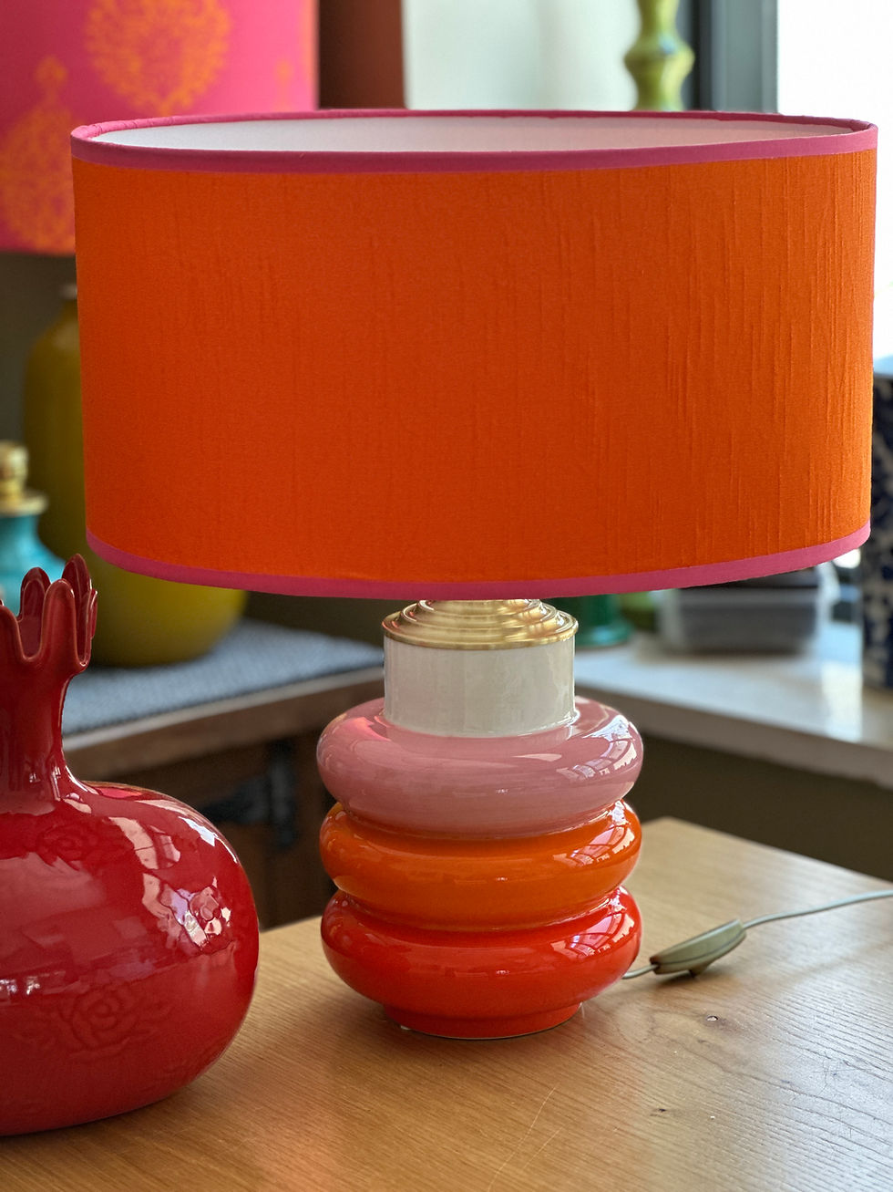 Thumbnail: Bold table lamp with orange, pink, and red ceramic base and a bright orange lampshade with pink trim.