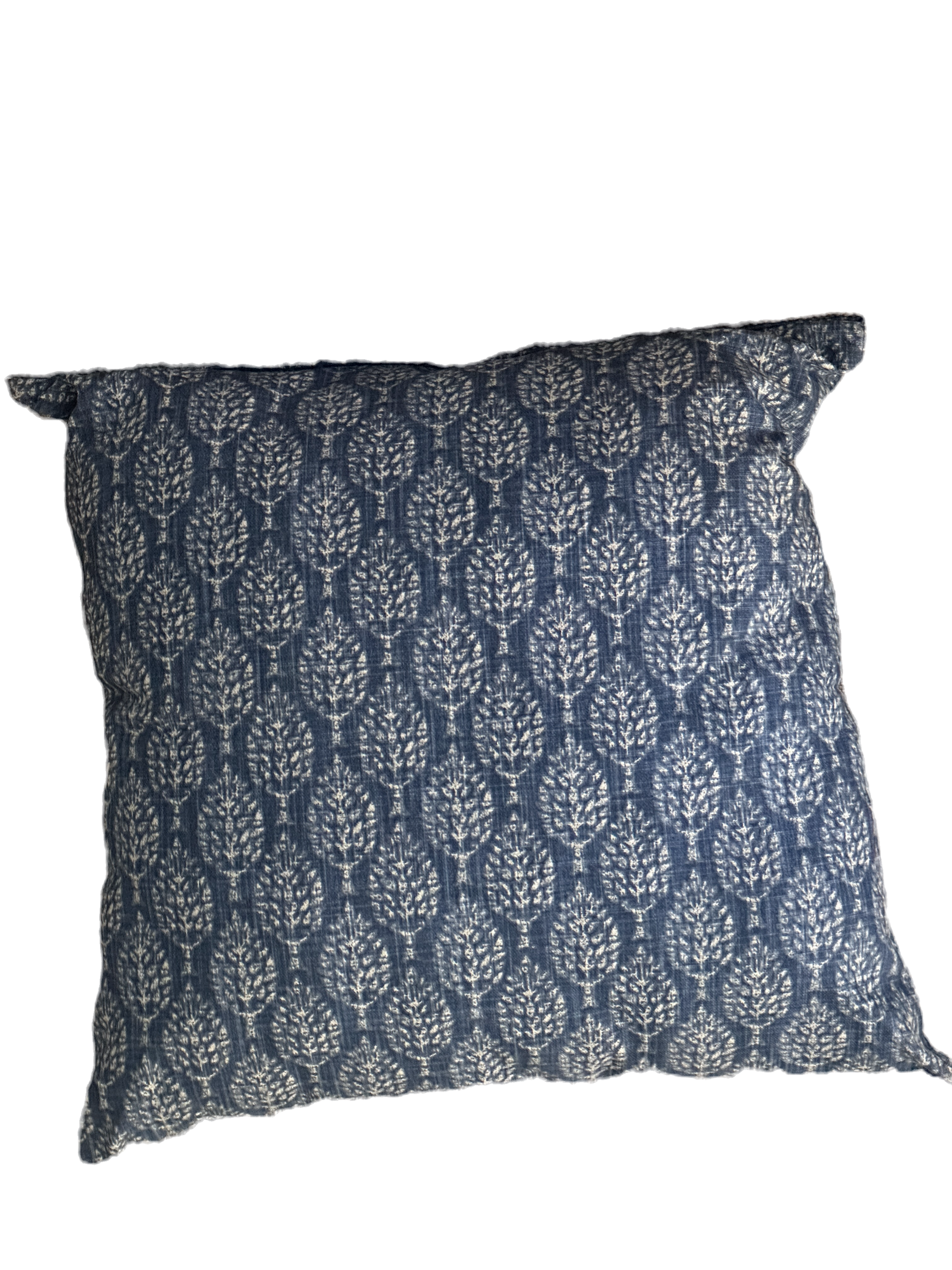 Indigo blue cushion with a white leaf motif on textured fabric.