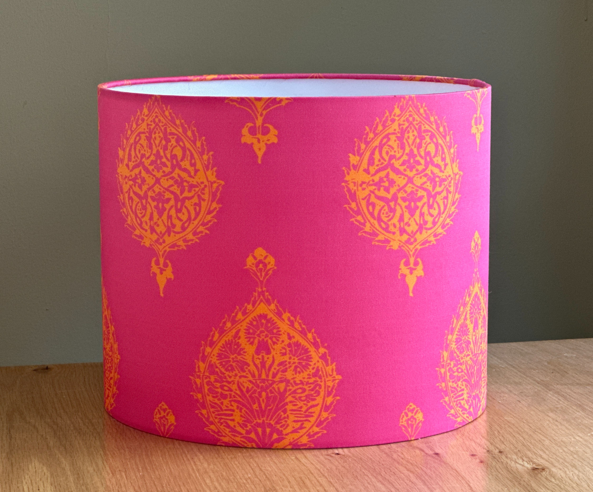 Bright pink fabric lampshade with vivid orange traditional Indian-inspired patterns.