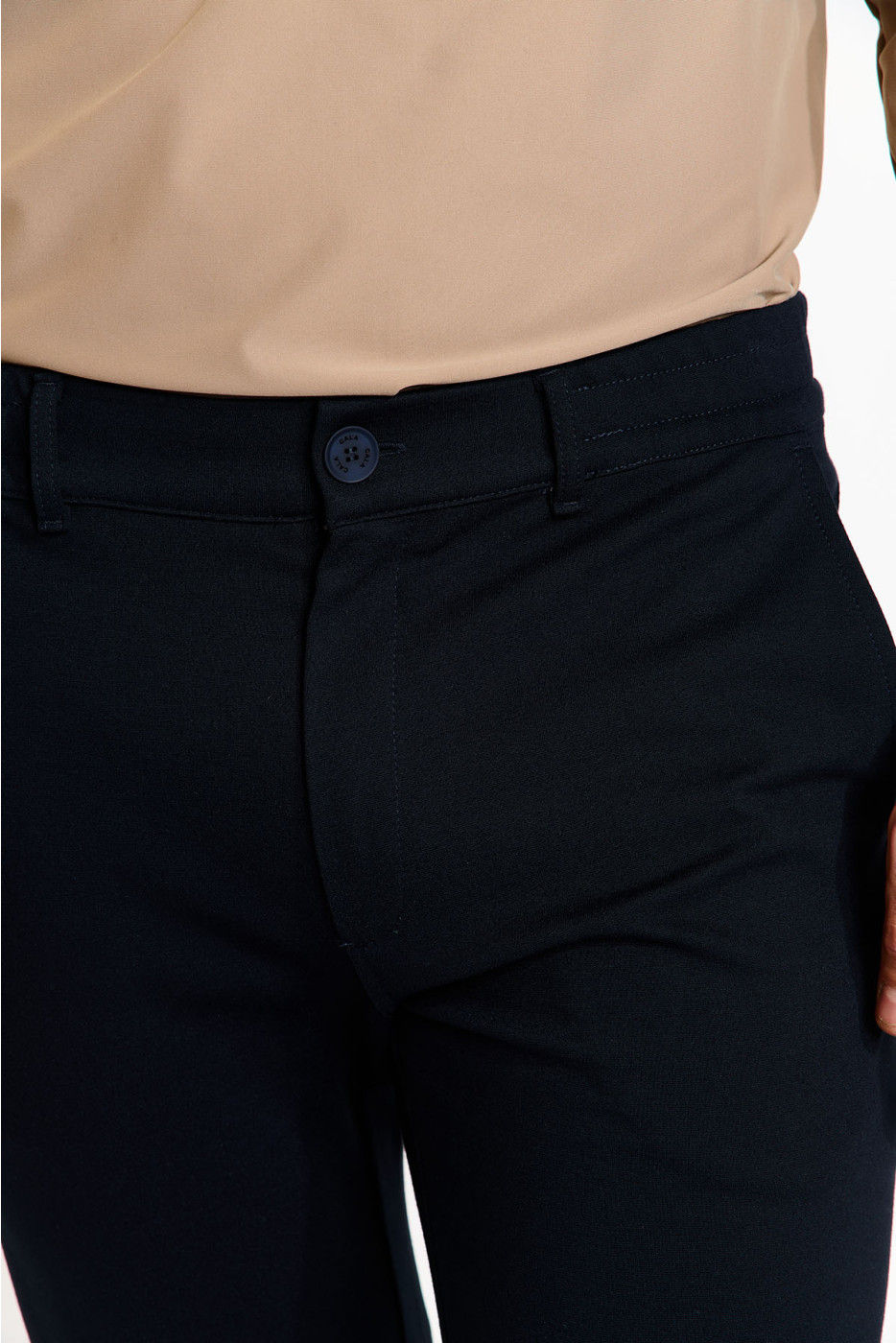 Gros plan sur pantalon bleu marine, bouton et chemise beige. Boutique Karsenty