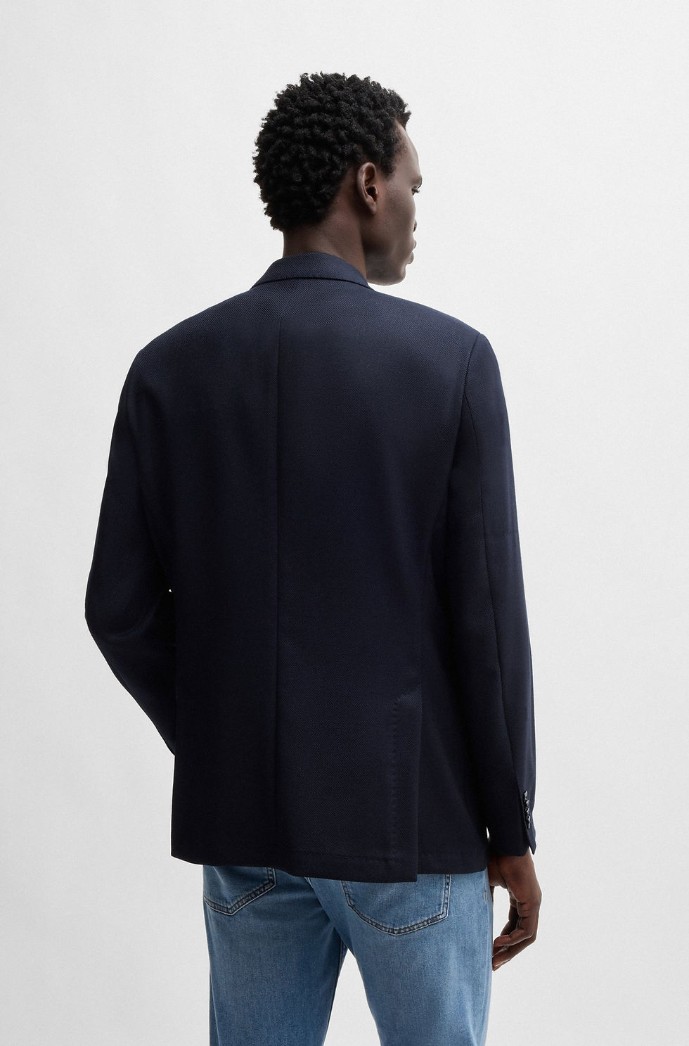 Miniature : Homme portant une veste bleu marine, vue arrière contre un mur blanc.