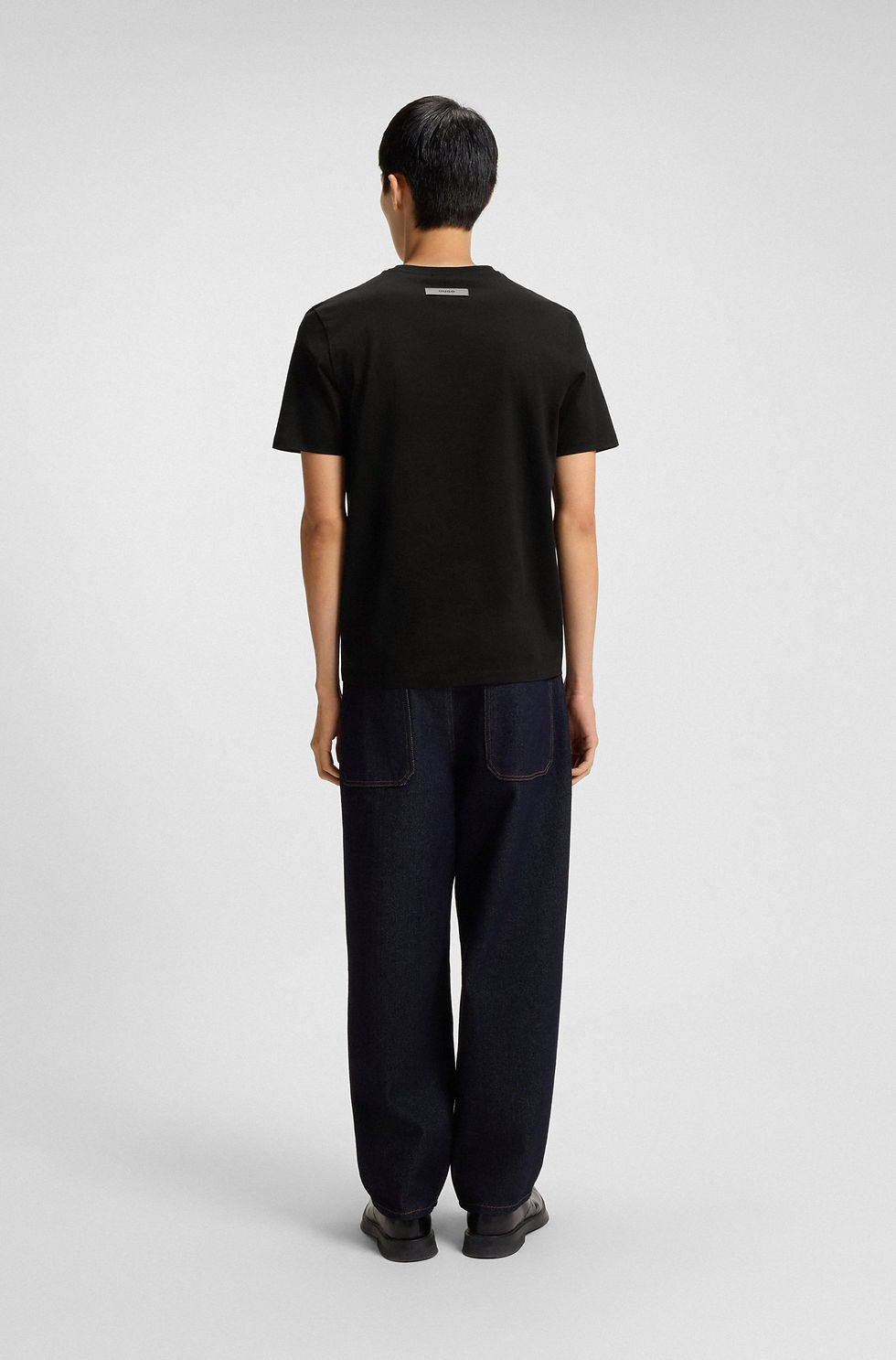Miniature : Homme portant un t-shirt noir avec texte, T-shirt slim en coton mercerisé, et jean bleu