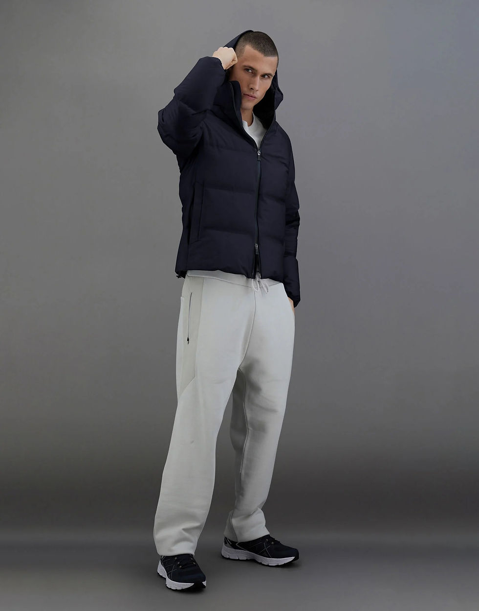Miniature : Homme portant une veste matelassée et un pantalon gris, fond neutre.