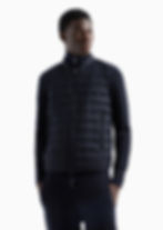 Homme portant une veste sans manches rembourrée noire, zipper, et col montant.