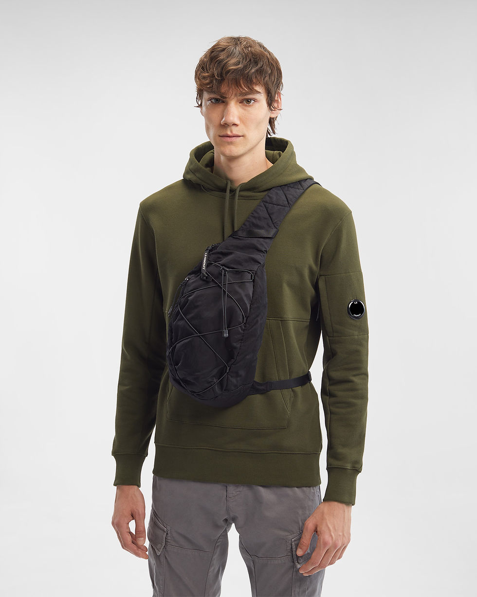 Miniature : Homme portant un sac bandoulière noir devant un fond vert, Boutique Karsenty.