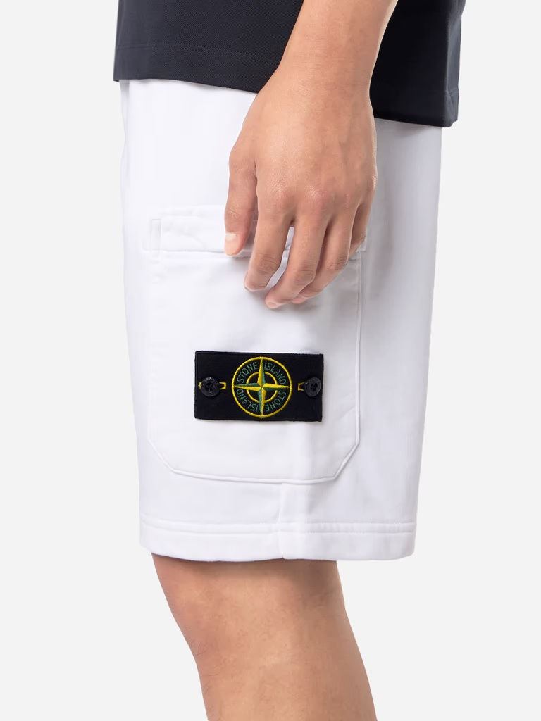 Miniature : Gros plan sur short blanc Stone Island, poche et logo sur fond clair.