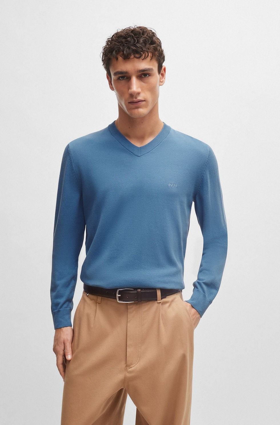 Un homme porte un pull bleu 63051 COTTON FLEECE, avec un pantalon beige. Boutique Karsenty