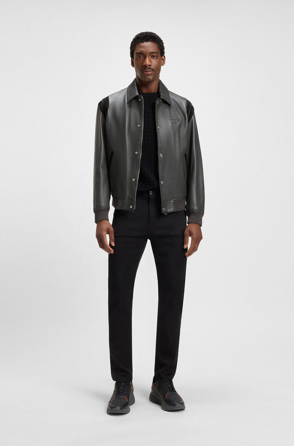 Homme porte une veste en cuir noire et un jean noir, Boutique Karsenty.