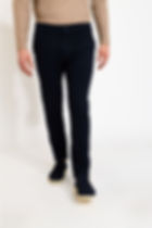 Homme debout portant un pantalon bleu marine avec des chaussures Boutique Karsenty.