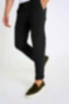 Homme en pantalon noir pose, fond blanc. Boutique Karsenty.