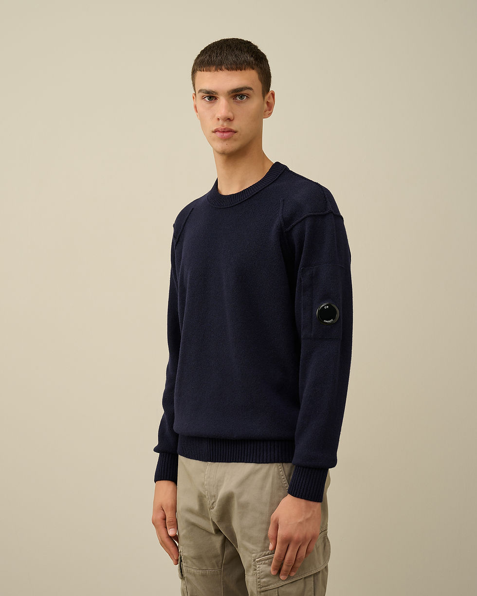 Homme portant un pull-over bleu marine, avec détail sur la manche. Boutique Karsenty.