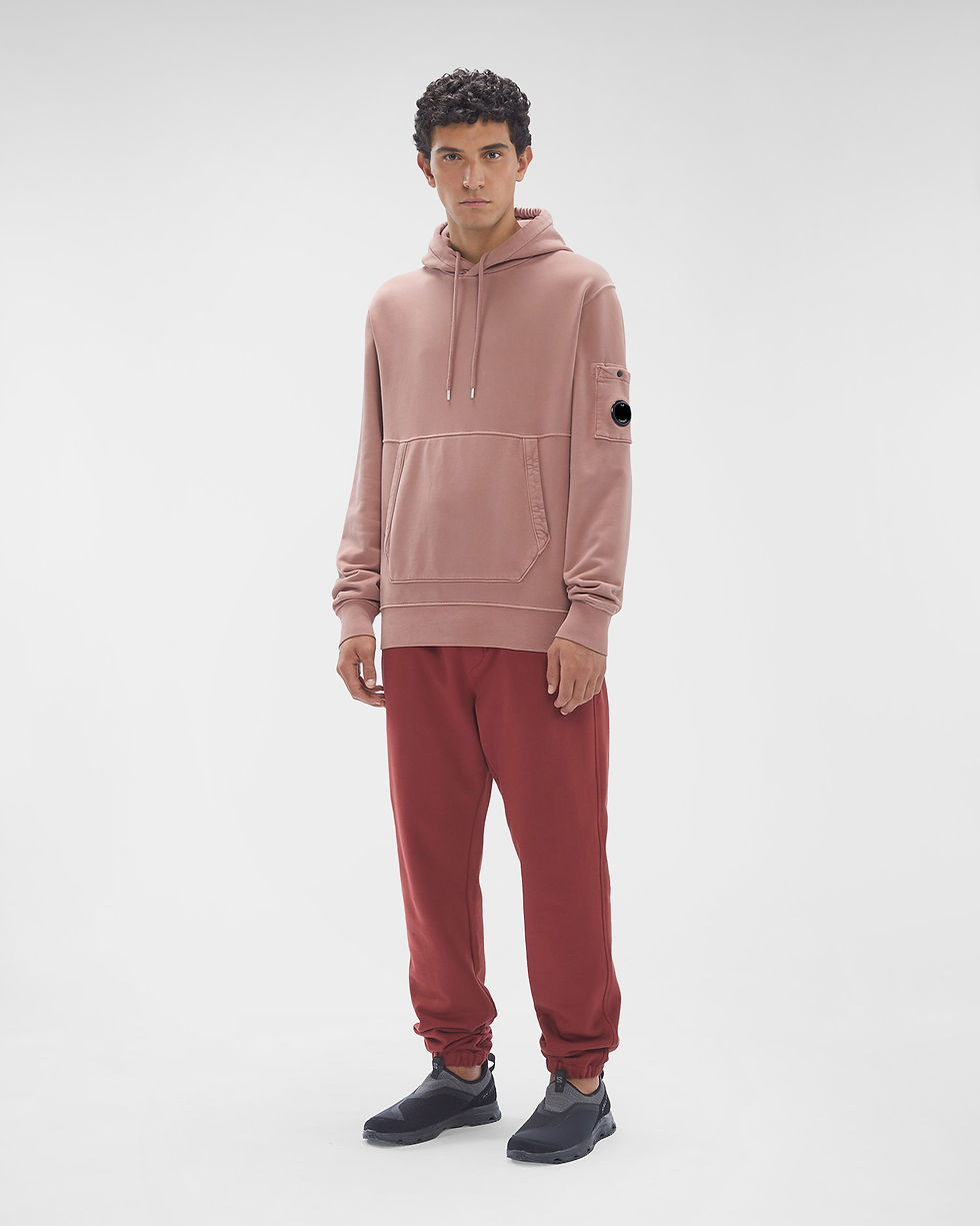 Miniature : Homme portant un sweat à capuche rose et un pantalon rouge, debout.