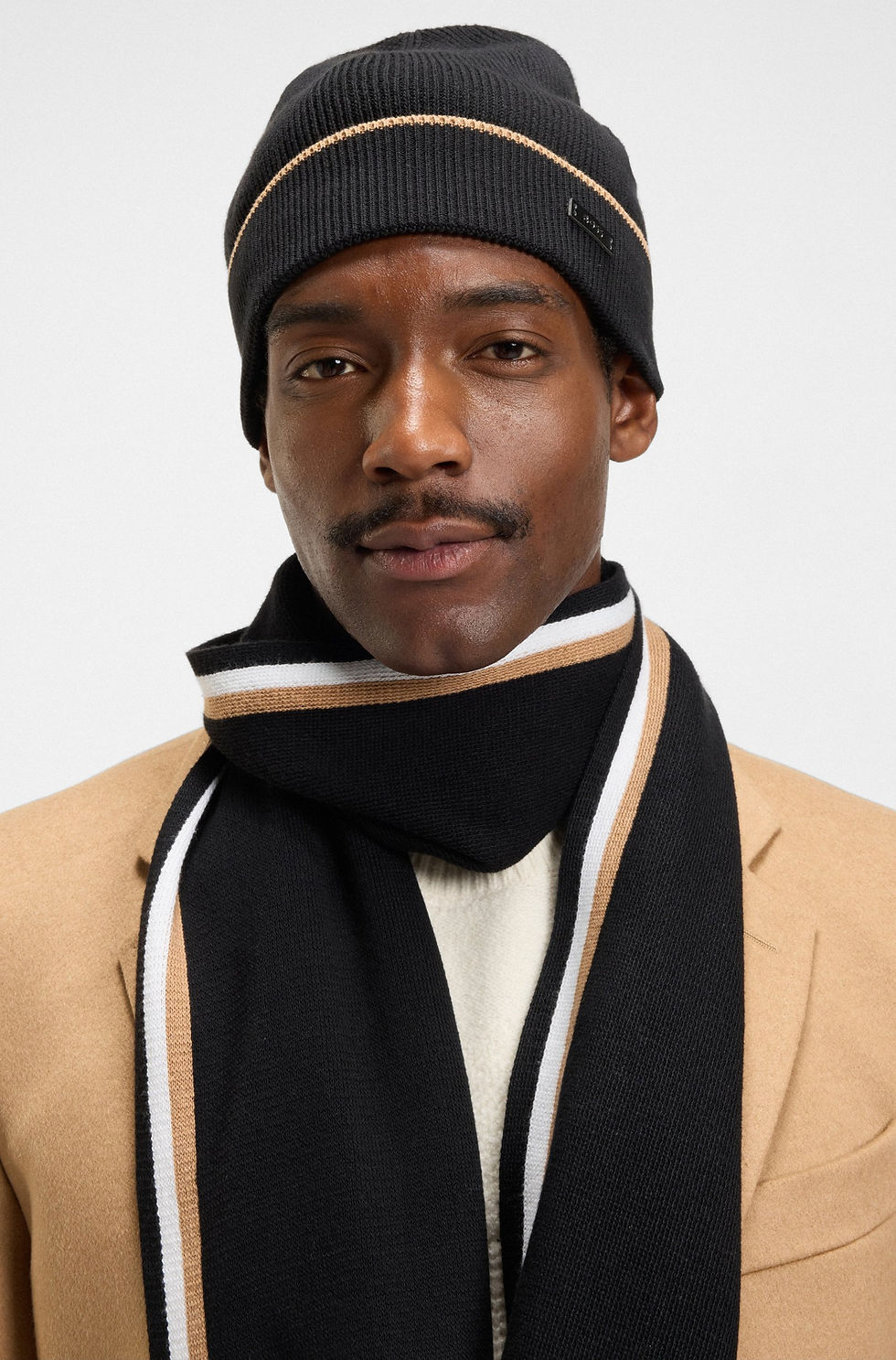 Miniature : Homme portant un bonnet et une écharpe noirs et beiges, Boutique Karsenty.