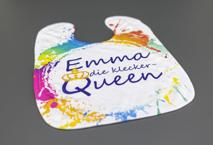 bunter babylatz bunt bedruckt mit emma die klecker queen auf einem grauen untergrund