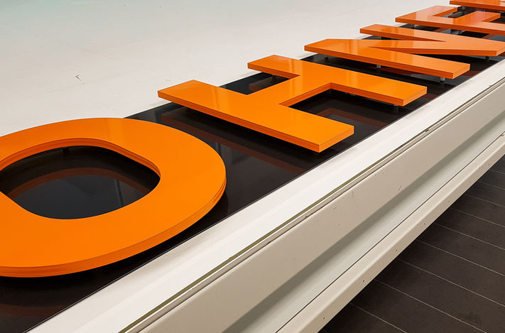 Orange einzelbuchstaben auf einem tisch die zur montage vorbereitet werden