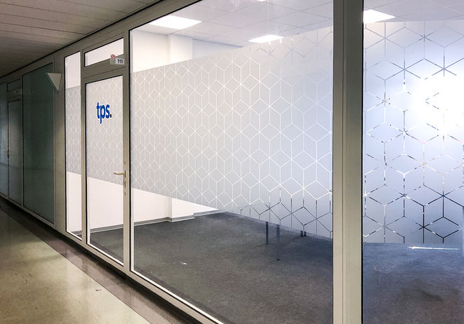 Büro-Glaswände mit Sichtschutzfolie, Logo "tps.", geometrisches Muster für Privatsphäre.