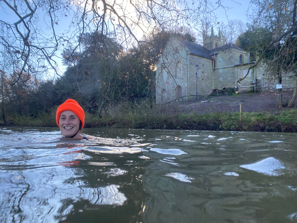 Melanie with an orange hat in a river